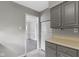View of the kitchen with gray cabinets, a white refrigerator, and an open flow to a living area at 141 S 9Th Ave, Beech Grove, IN 46107