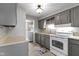 Functional kitchen featuring gray cabinets, white appliances, and a view into the laundry room at 141 S 9Th Ave, Beech Grove, IN 46107