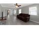 Inviting living room featuring light gray walls, laminate flooring, ceiling fan, and a comfortable brown sofa at 141 S 9Th Ave, Beech Grove, IN 46107
