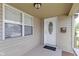 Inviting covered porch featuring a white front door with oval glass insert, complemented by neutral siding and a window at 141 S 9Th Ave, Beech Grove, IN 46107