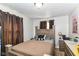 This bedroom has a large bed, an accent wall, and a large window with neutral-colored curtains at 1619 E Bradbury Ave, Indianapolis, IN 46203