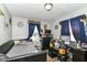 This bedroom has a twin bed, Steelers memorabilia, and natural light from the large window with blue curtains at 1619 E Bradbury Ave, Indianapolis, IN 46203