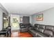 Comfortable living room with hardwood floors and a plush gray leather sofa at 1619 E Bradbury Ave, Indianapolis, IN 46203
