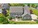 An aerial view of a brick home with a landscaped yard, long drive, and red door at 16802 Oak Manor Dr, Westfield, IN 46074
