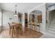 Open dining area with hardwood floors, stylish chandelier, and convenient breakfast bar adjacent to the kitchen at 16802 Oak Manor Dr, Westfield, IN 46074