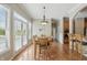 Sunlit dining area featuring hardwood floors, a modern chandelier, and views to outside, perfect for Gathering meals at 16802 Oak Manor Dr, Westfield, IN 46074