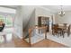 Open staircase leading to an entry to a formal dining room with a dark wood table and furnishings at 16802 Oak Manor Dr, Westfield, IN 46074