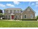 Brick two story home with a manicured lawn and a vibrant red front door exudes classic charm at 16802 Oak Manor Dr, Westfield, IN 46074