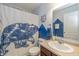 A well-lit bathroom with a sink, toilet, shower with a bear themed curtain and mountain themed art at 1696 Woodfield Dr, Greenwood, IN 46143