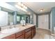 Bathroom featuring double sinks, wood cabinets, and a large mirror at 1696 Woodfield Dr, Greenwood, IN 46143