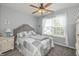 A bedroom featuring a bed, bedside table, ceiling fan, and a window providing natural light at 1696 Woodfield Dr, Greenwood, IN 46143