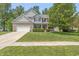 Charming two-story home with a well-manicured lawn and inviting front porch at 1696 Woodfield Dr, Greenwood, IN 46143