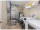 A well-lit laundry room featuring new washer and dryer units, utility sink and storage at 1696 Woodfield Dr, Greenwood, IN 46143