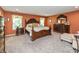 Spacious bedroom featuring a king bed, hardwood furniture, and neutral carpet at 1696 Woodfield Dr, Greenwood, IN 46143