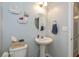Half bath featuring a pedestal sink, oval mirror, and decorative shelving at 1696 Woodfield Dr, Greenwood, IN 46143