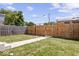 Fenced backyard with a well maintained lawn and a concrete walking path at 1709 Fletcher Ave, Indianapolis, IN 46203