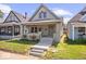 Charming home featuring a gabled roof, inviting front porch, and well-manicured lawn at 1709 Fletcher Ave, Indianapolis, IN 46203