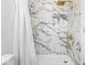 Elegant shower featuring marble-patterned tile, gold fixtures, and a rain shower head at 1709 Fletcher Ave, Indianapolis, IN 46203