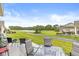 Backyard oasis featuring a patio with outdoor seating, lush lawn, landscaping and serene lake view at 17309 Graley Pl, Westfield, IN 46074