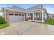 Charming home featuring a brick facade, gray siding, covered front porch, and attached two-car garage at 17309 Graley Pl, Westfield, IN 46074