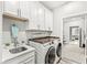 Well-lit laundry room with modern washer and dryer, sink, countertops, and ample cabinet space at 17309 Graley Pl, Westfield, IN 46074