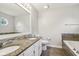 Bathroom featuring a bathtub, granite countertops, double sinks, modern toilet, and decorative mirror at 17357 Austrian Pine Way, Westfield, IN 46074