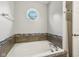 A well-lit bathtub beneath an octagonal window offers a serene bathing experience at 17357 Austrian Pine Way, Westfield, IN 46074