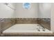 A bathtub with tile surround and an octagonal window provides natural light at 17357 Austrian Pine Way, Westfield, IN 46074