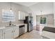 Open kitchen with stainless steel appliances and view of the dining area with sliding glass doors at 17357 Austrian Pine Way, Westfield, IN 46074