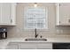Kitchen with white cabinets, sleek black hardware, and a stainless steel sink near the window at 17357 Austrian Pine Way, Westfield, IN 46074
