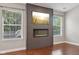 Living room showcasing a modern fireplace feature wall with mounted television and natural light from two windows at 17357 Austrian Pine Way, Westfield, IN 46074