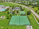 Aerial view of tennis courts, a basketball court, and community amenities with a lake at 17357 Austrian Pine Way, Westfield, IN 46074