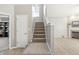 Carpeted stairs with a white banister leading to the upper level, next to a door and a view of the living room at 1829 Archbury Dr, Avon, IN 46123