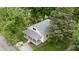 Aerial view of a charming home with a covered porch, surrounded by lush trees at 204 S Conger St, Saint Paul, IN 47272