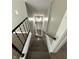 Staircase featuring neutral walls and carpet steps with a black and wood handrail at 204 S Conger St, Saint Paul, IN 47272