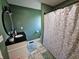 Bathroom featuring a shower with a floral curtain and a vanity with a black countertop and round mirror at 2041 Mckinley Ave, Columbus, IN 47201
