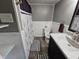 Bathroom featuring a gray vanity, a toilet with a patterned seat cover and a shower with a patterned curtain at 2041 Mckinley Ave, Columbus, IN 47201