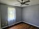 Bedroom featuring hardwood floors, ceiling fan, a window with curtains and gray walls at 2041 Mckinley Ave, Columbus, IN 47201