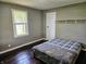 Bedroom showcasing a bed with gray and plaid bedding, a window, and a built-in shelf above the bed at 2041 Mckinley Ave, Columbus, IN 47201