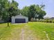 Oversized two car garage with a basketball hoop in the large yard and lush trees at 2041 Mckinley Ave, Columbus, IN 47201
