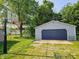 Exterior view of detached garage with a basketball hoop and large trees in the background at 2041 Mckinley Ave, Columbus, IN 47201