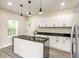 Modern kitchen with white cabinets, granite countertops, stainless appliances, and stylish pendant lighting at 2427 N Rural St, Indianapolis, IN 46218