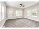 Bright living room with wood flooring, ceiling fan and three large windows at 2427 N Rural St, Indianapolis, IN 46218