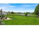 Expansive backyard featuring a lush lawn, mature trees, and a serene pond view at 2434 Burgundy Way, Plainfield, IN 46168