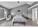 This bedroom features gray walls, a ceiling fan, a gray upholstered bed, an armchair, and an ensuite bathroom at 2434 Burgundy Way, Plainfield, IN 46168