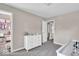This bedroom features light beige walls, a white crib, a white dresser, and an adjacent closet at 2434 Burgundy Way, Plainfield, IN 46168