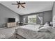 This bedroom features gray walls, a ceiling fan, a workstation, a flat screen TV, and a large window with curtains at 2434 Burgundy Way, Plainfield, IN 46168
