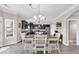 Open dining area with a wood table, seating for six, and views of the modern kitchen with stainless steel appliances at 2434 Burgundy Way, Plainfield, IN 46168