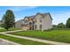 Two-story home boasts manicured lawn, attached garage, and appealing architectural details under a blue sky at 2434 Burgundy Way, Plainfield, IN 46168