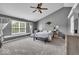 Spacious main bedroom featuring a vaulted ceiling, ceiling fan, sitting area, and a bright window for natural light at 2434 Burgundy Way, Plainfield, IN 46168